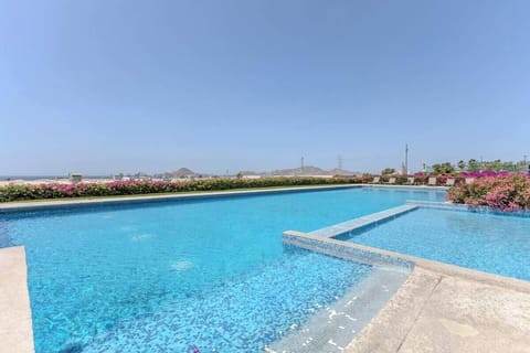 Serene poolside w/ crystal-clear water & loungers for relaxing under the sun
