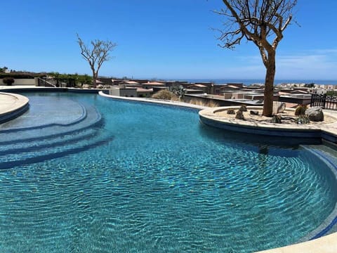 Shared pool w/ clear blue water & lounge chairs, perfect for sunny afternoons
