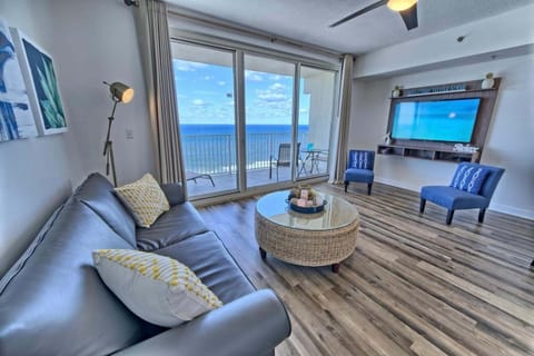 Open concept living area with stylish furnishings and huge TV + balcony access
