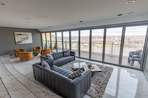 Bright, open-plan living area with floor-to-ceiling windows and seamless access to the private patio—perfect for relaxing with skyline views.