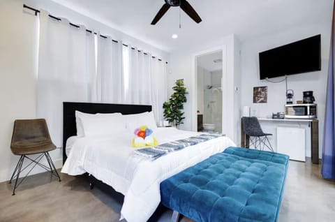Spacious king size sleeping area for guests with coffee station, microwave, and mini fridge.