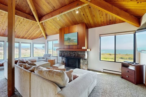 Morning light fills the living room, inviting you to unwind by the gas fireplace while gazing out at the breathtaking ocean horizon.
