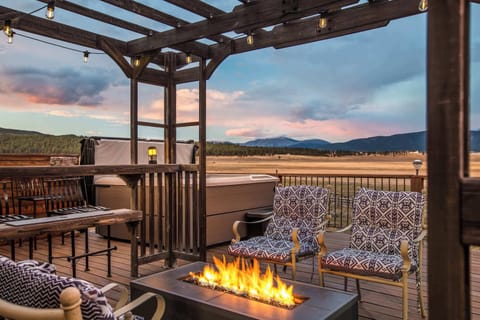Pergola deck with a fire table and open mountain views at sunset