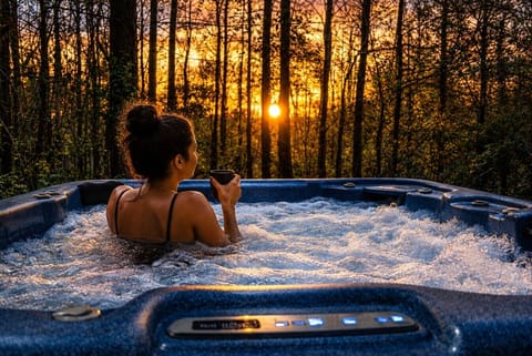 Relax and unwind in the private hot tub surrounded by peaceful wooded views.