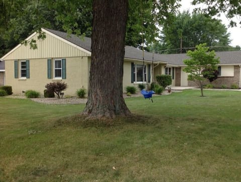 Large front yard with mature tree and swing along with a nice front porch.