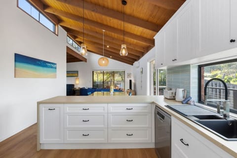 Bright, airy house kitchen with warm timber ceiling
