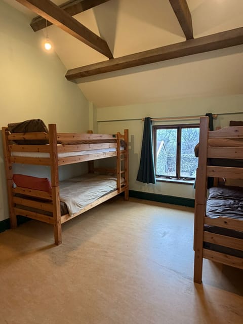 Comfortable four-bed bunk room with scenic window views, ideal for groups at Wern Watkin Bunkhouse.