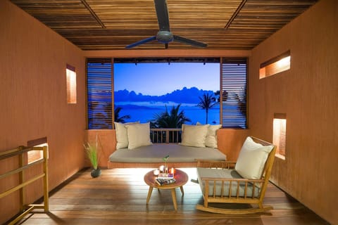 Lounge at sunset with panoramic views and cozy cushioned seating.