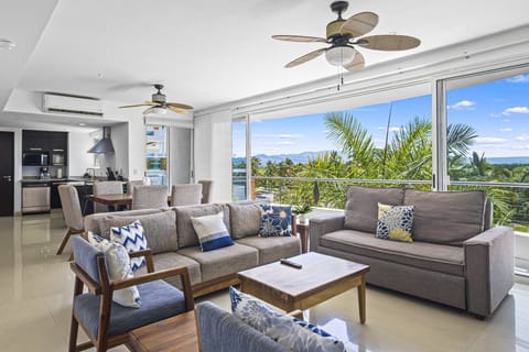 Relax in this bright and spacious living area featuring comfortable seating, modern décor, and beautiful tropical views. Perfect for unwinding after a day at the beach.