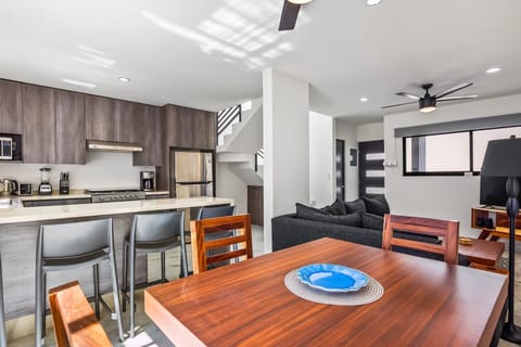 Relax in a spacious living and dining area featuring modern furnishings, natural light, and seamless access to the outdoor terrace.