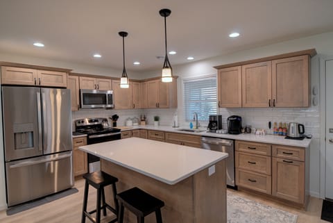 Large open kitchen fully stocked with pots, pans, utensils, blenders and more.