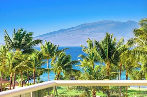 A peaceful island scene stretches out from your balcony with tropical gardens, resort pools, and ocean horizon. HKK-439