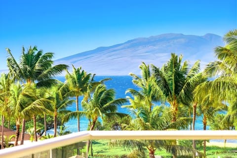 A peaceful island scene stretches out from your balcony with tropical gardens, resort pools, and ocean horizon. HKK-439
