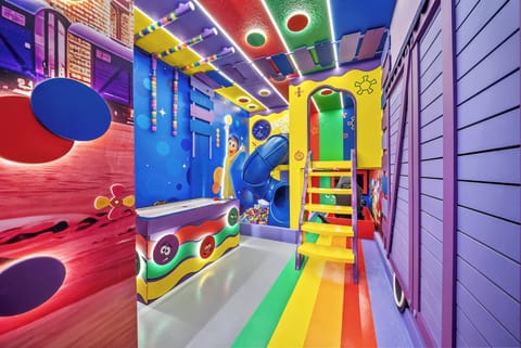 Step into a vibrant playroom where bold colors and creative designs spark joy and imagination. The lively rainbow staircase leads to endless fun, while playful murals and funky shapes create an energizing atmosphere for all ages.