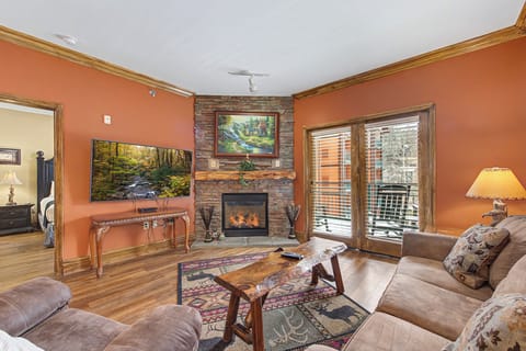 Curl up by your stone fireplace in this cozy living room where warm earth tones and soft furnishings create the perfect retreat.