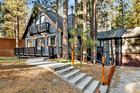 Welcoming cabin entry surrounded by towering pine trees, offering fresh mountain air and a peaceful forest setting—the perfect first impression for your Big Bear Lake getaway.