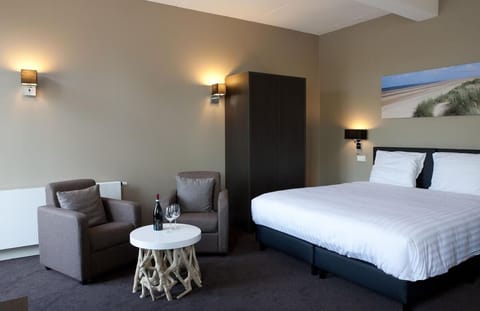 Unwind in a plush bed with a cozy lounge corner.