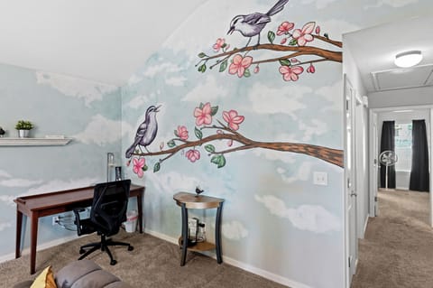 The corner of the living room offers a comfortable chair and desk for working.