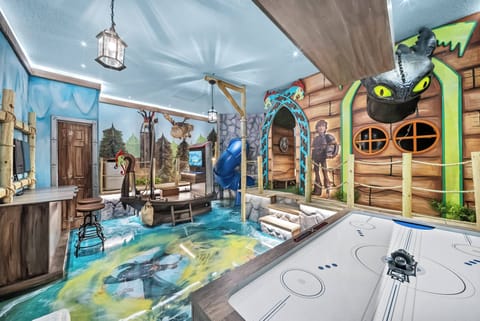 Step into a whimsical adventure with vibrant murals and playful decor that spark imagination. The unique flooring and ceiling details create a fun atmosphere, while the air hockey table invites friendly competition and laughter.