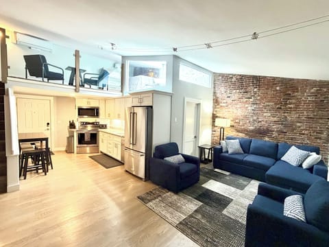 Large open concept living space with tall sloped celling and a loft.