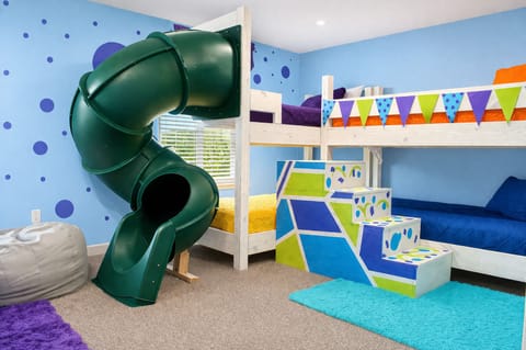 Kids' Adventure Room: Dive into excitement with a slide, vibrant bunks, and play