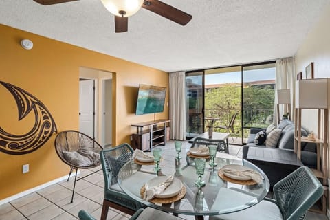 Modern island living! ✨ Relax in this bright, stylish space featuring chic teal seating and vibrant mural art. 🎨 Open the sliding doors to your lush balcony retreat. 🌴🏡 Your dream getaway! 🌊🍹