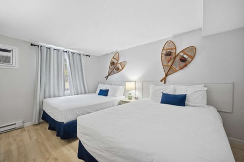 The bedroom features a pair of plush queen beds & a smart TV​