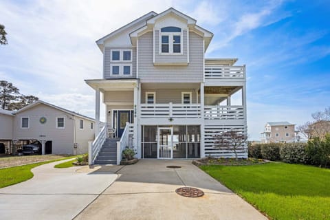 This stunning soundfront home in Kill Devil Hills offers panoramic water views and unforgettable sunsets from every level.