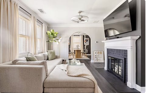 Living space with a fireplace, a smart TV, and large windows for natural light.