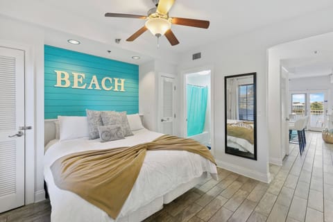 Your coastal bedroom retreat features a stunning turquoise accent wall and crisp white bedding, creating the perfect beachy vibe for restful nights.