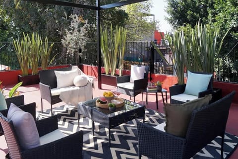 A spacious rooftop setting framed by greenery and open skies. Layered seating, warm light, and generous outdoor space invite long afternoons, relaxed gatherings, and unhurried moments under the sun.