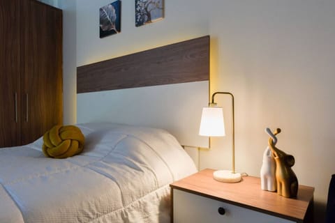 Recámara con cama Queen size, lámpara de noche y cortinas black-out para un descanso óptimo. Cuenta con clóset, además de plancha y burro de planchar para mayor comodidad durante tu estancia.