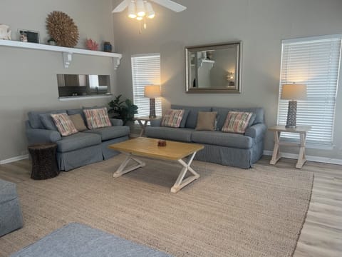 Relax in this stylish living room with plush seating, natural light, and thoughtful coastal touches that create your perfect home away from home.