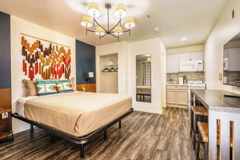 Cozy studio with vibrant decor and a fully equipped kitchenette, perfect for a comfortable stay.