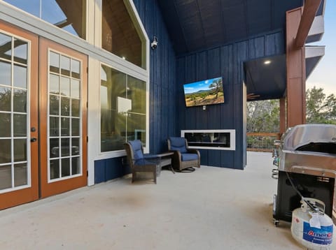 Covered outdoor living with BBQ, TV, and multiple seating zones for relaxed evenings together