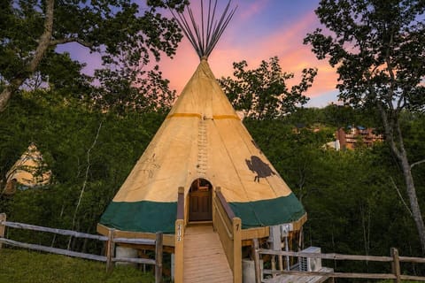Stunning sunset view of the luxury teepee exterior with warm, ambient lighting.