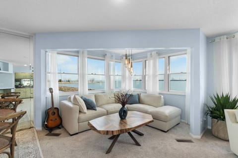 Relax in the sunlit lounge with panoramic water views and Cedar Point visible in the background