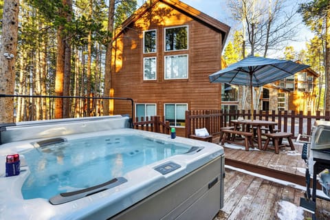 Back deck view featuring a relaxing hot tub and outdoor dining area.