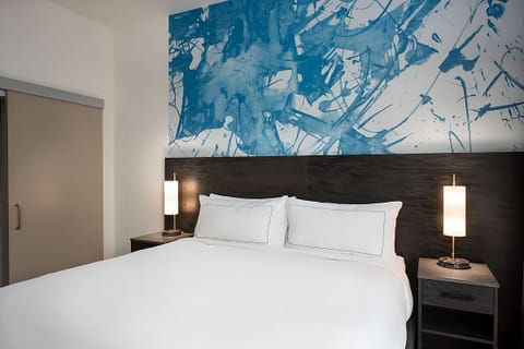 Sink into crisp linens beneath bold, modern artwork accents.