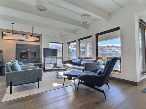 【Living Room】Wall of mountain windows and a sectional — where the crew lands when ski boots come off