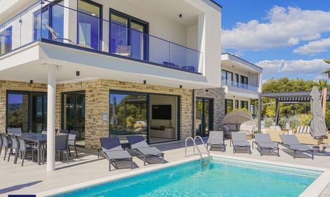 This luxurious villa in Primošten offers not only a beautiful and privileged surrounding but also a view of its own thanks to its modern architecture. Under the sun, you can take a swim in the heated pool and relax on numerous loungers, tan in the sun and above all, you can enjoy the day to its fullest.