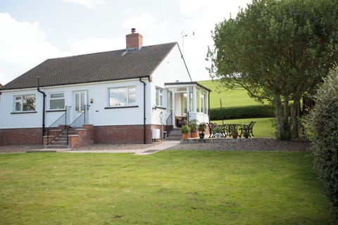 Wall & Lakes Holiday Cottage, white bungalow, countryside views, lawn and patio