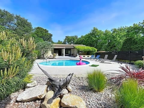 Pool equipped with a safety alarm, lounge chairs, and a beach umbrella