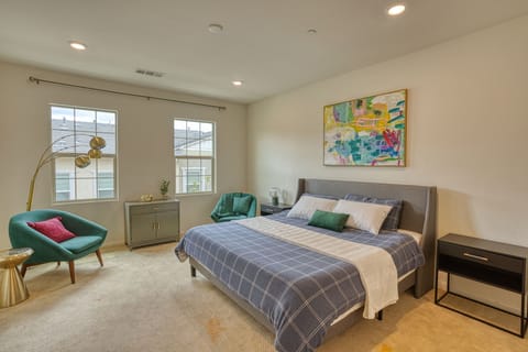 Spacious primary suite featuring a king bed and vibrant, modern decor