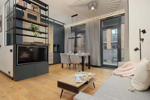 A modern living room combined with a dining area, dominated by an elegant dark-colored TV cabinet.