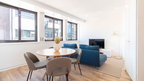 Bright open-plan living and dining area with natural light pouring through large windows, designed for relaxed city stays. #PortoLiving #ModernStay #CityLight