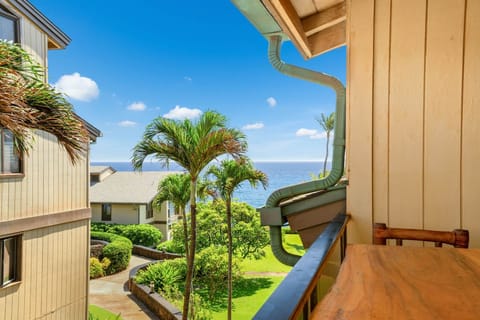 Lanai view of tropical grounds, palm trees, and a partial ocean view