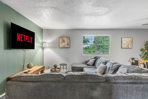 Spacious and inviting living area with comfortable seating and a smart TV, perfect for relaxing after exploring Arlington or attending events at AT&T Stadium.
