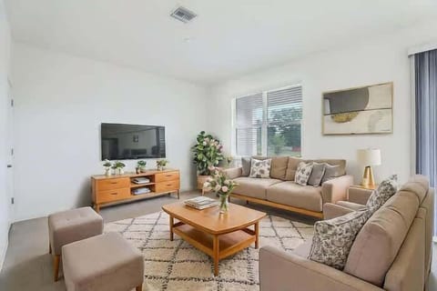 Relax in this cozy living room with ample seating, natural light, and a modern TV setup, perfect for unwinding after a day of adventure.