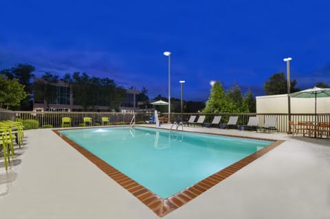 Unwind under evening lights with a refreshing, sparkling swim.
